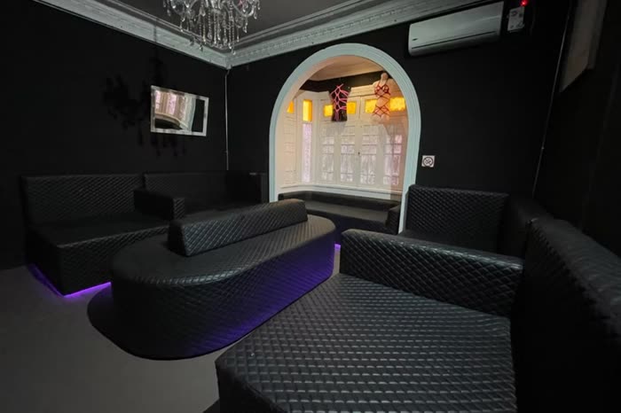 Sala privada con sillones de cuero y luz violeta en Sinners Club, Bellavista